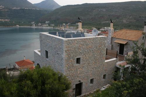 a stone building with a view of a body of water at Traditional Apartments Plagiaki in Neon Oitilon