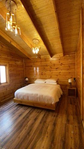 a bedroom with a bed in a wooden cabin at أكواخ البرنسيسة in Jeddah