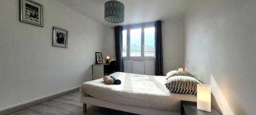 une chambre blanche avec un lit et une fenêtre dans l'établissement Le Ferrié - 3 Chambres - Parking Gratuit - proche centre ville, à Grenoble