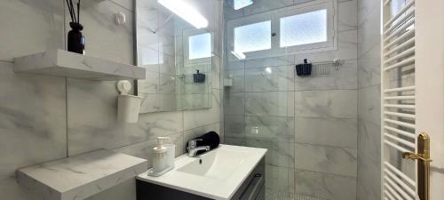 une salle de bain blanche avec un lavabo et une douche dans l'établissement Le Ferrié - 3 Chambres - Parking Gratuit - proche centre ville, à Grenoble
