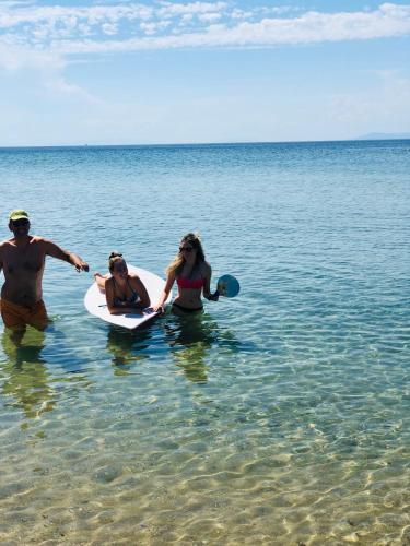 a group of people in the water at the beach at Byblos Luxury Villa in Prinos