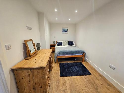 a bedroom with a bed and a wooden table at The Dairy in Swindon