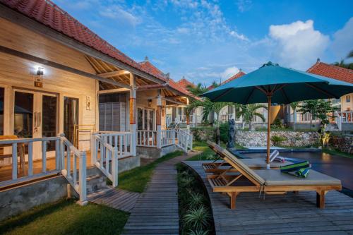 a patio with a table and an umbrella at Blue Sky Villa Ceningan in Nusa Lembongan