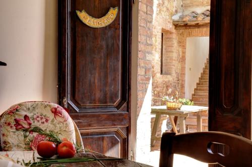a room with a wooden door with tomatoes on a table at Borgo San Lorenzo a Linari in San Rocco a Pilli