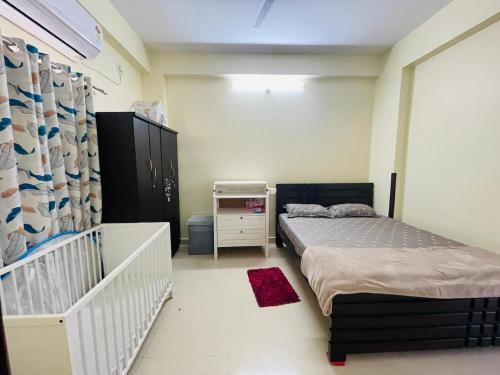 a bedroom with a twin bed and a crib at Peaceful 2 Bedroom Flat near Airport in Hyderabad