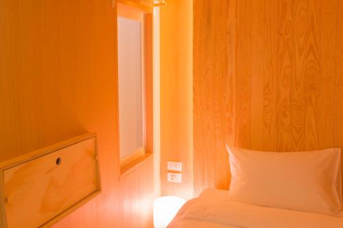 a bedroom with a bed with a window and a pillow at Boxtel @ Suvarnabhumi Airport in Lat Krabang