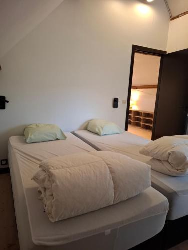 two beds sitting next to each other in a bedroom at Tsjaka+ in Ronse