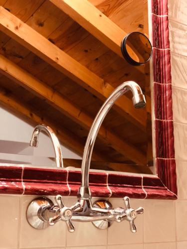 a kitchen sink faucet in front of a mirror at Casal da Serrana in Óbidos