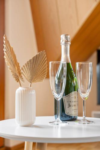 a bottle of wine and two glasses on a table at Ferienwohnung "Ruhe und Weitblick" Perfekte Anbindung in Illingen