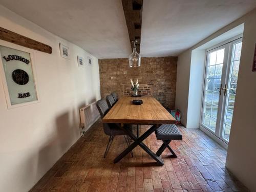 a dining room with a wooden table and chairs at The old pub in Docking in Docking
