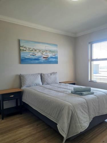 a bedroom with a bed and a painting on the wall at View At The Bay in Mossel Bay
