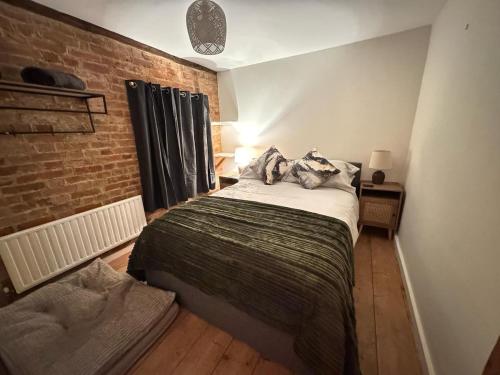a bedroom with a bed and a brick wall at The old pub in Docking in Docking