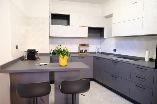 a kitchen with a large island with two stools at Stay&Go - Bilocale con Giardino in Pregnana Milanese