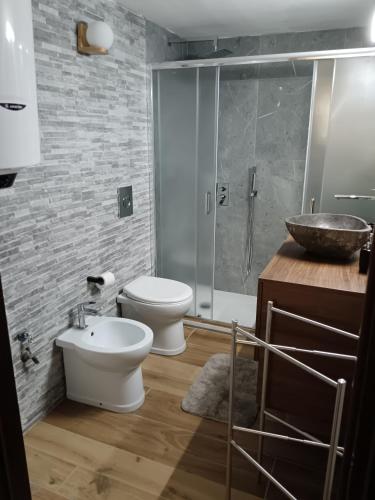 a bathroom with a toilet and a sink and a shower at Bilocale Centro Valtournenche in Valtournenche