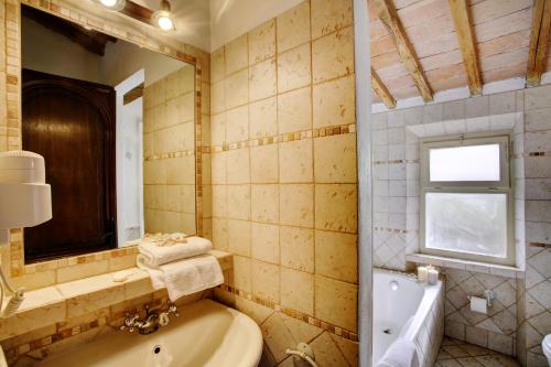 a bathroom with a tub and a sink and a mirror at Borgo San Lorenzo a Linari in San Rocco a Pilli