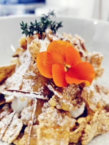 ein Teller mit Essen und einer Blume darauf in der Unterkunft Di Prima Albergo Diffuso in Catania