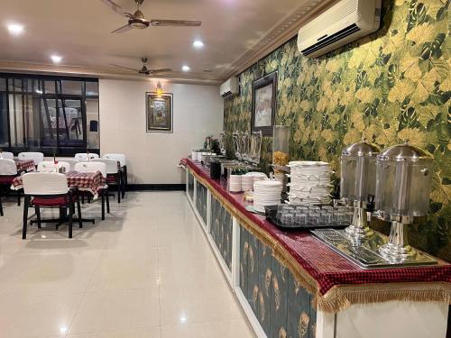 班加罗尔S V COMFORTS B T M Layout的设有自助餐台、桌椅的餐厅