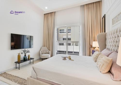 a white bedroom with a large bed and a tv at Dream Inn - Modern 1BR in Arjan in Dubai
