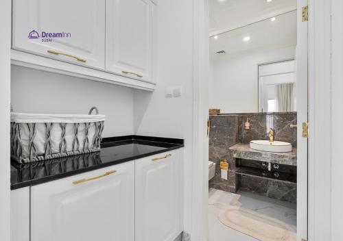 a white bathroom with a sink and a toilet at Dream Inn - Modern 1BR in Arjan in Dubai