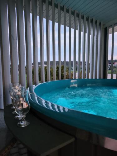 a jacuzzi tub on a balcony with a window at Atostogų pieva in Žibininkai