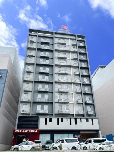 a tall building with cars parked in front of it at Red Planet Cagayan De Oro in Cagayan de Oro