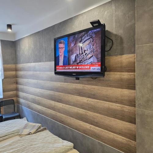 a television on a wall in a bedroom at Pokoje Gościnne Polo in Częstochowa