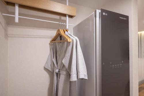 a towel hanging on a rack next to a refrigerator at H-Avenue Hotel Haeundae in Busan