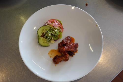 a white plate with meat and vegetables on a table at Kili Seasons Hotel in Arusha