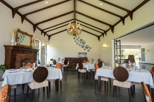 a dining room with tables and chairs and a chandelier at Kili Seasons Hotel in Arusha