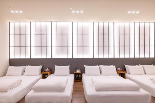 a room with white couches and a large window at H-Avenue Hotel Haeundae in Busan