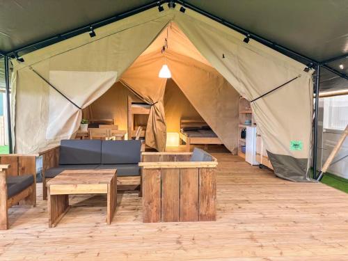 a large tent with a table and benches in it at Toftum Bjerge Camping & Cottages in Humlum