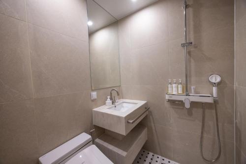 a bathroom with a sink and a toilet and a shower at H-Avenue Hotel Haeundae in Busan