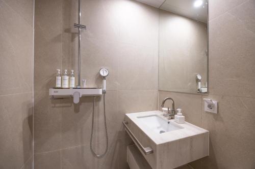 a bathroom with a sink and a shower at H-Avenue Hotel Haeundae in Busan