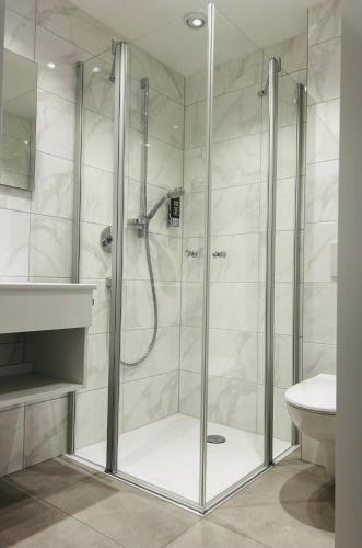 a shower with a glass door in a bathroom at Landhotel Sonnenbühl in Sonnenbühl