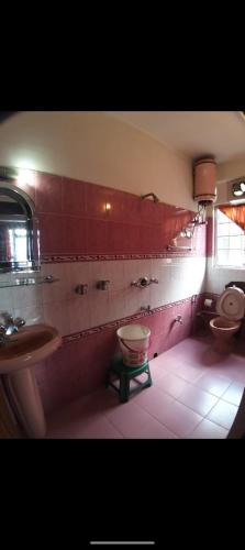 a bathroom with two toilets and a sink and a tub at Himalayan tea pot in Darjeeling