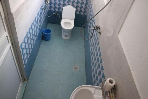 a small bathroom with a toilet and a sink at Hong Qi Hotel in Chitwan