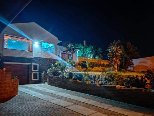 a house with lights on the side of it at night at MayBach Hills Palace Guesthouse in Saldanha