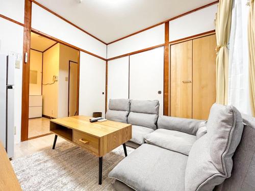 a living room with a couch and a table at Kongming House 孔明戸建て in Osaka