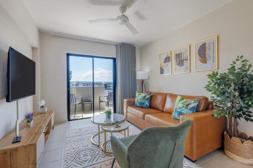 Una sala de estar con un sofá y un televisor. en Bliss Ballito Apartments, en Ballito