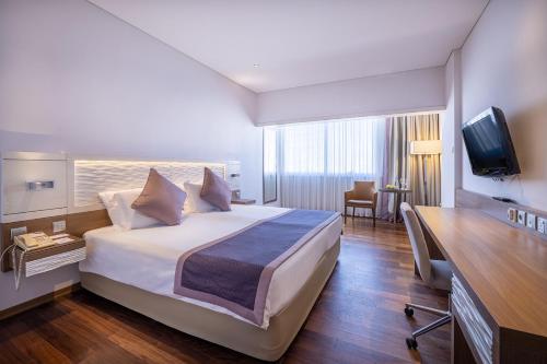 a hotel room with a bed and a television at Crowne Plaza Limassol by IHG in Limassol