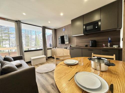 Il comprend une cuisine et un salon avec une table en bois. dans l'établissement Résidence Le Forest - COCOON A LA MONTAGNE MAE-7911, à Vars