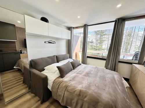 une chambre avec un lit et une grande fenêtre dans l'établissement Résidence Le Forest - COCOON A LA MONTAGNE MAE-7911, à Vars