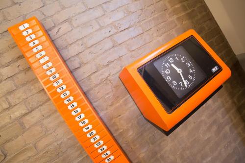 an orange clock sitting on the floor with a ruler at The Bellini House by House In Naples in Naples