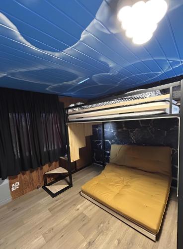 Ce lit se trouve dans un dortoir doté d'un plafond bleu. dans l'établissement Le Chalet - Changer d'air en Moselle, à Longeville-lès-Saint-Avold