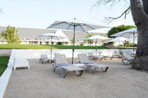 a group of white chairs and umbrellas at Kili Seasons Hotel in Arusha