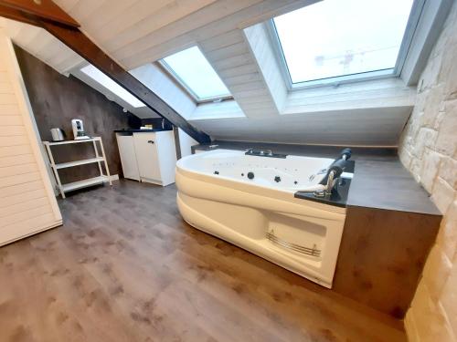 a bathroom with a bath tub in a attic at L'Opale - Sauna et Jacuzzi in Dijon