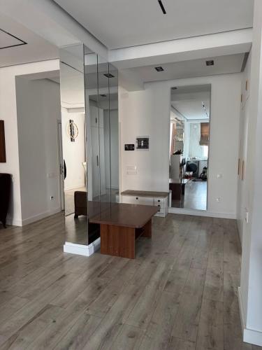 a living room with a wooden table and a mirror at Апартаменты в центре Худжанда in Khujand