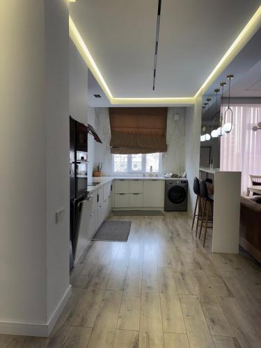 a large kitchen with white cabinets and a kitchen island at Апартаменты в центре Худжанда in Khujand