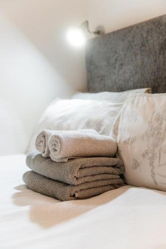 a pile of towels sitting on top of a bed at Abbey Point Hotel in London