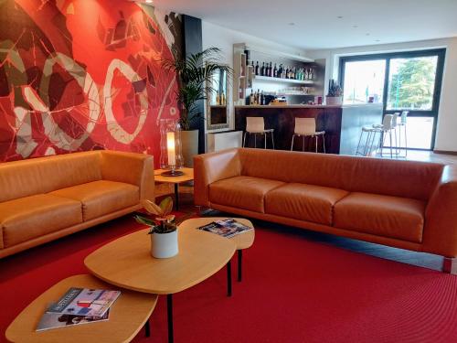 a living room with two couches and tables at Hotel Villa Maria in Desenzano del Garda